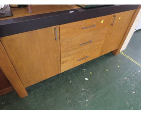 LIGHT OAK VENEER SIDEBOARD WITH THREE CENTRAL DRAWERS AND SINGLE CUPBOARD DOORS TO EACH END.