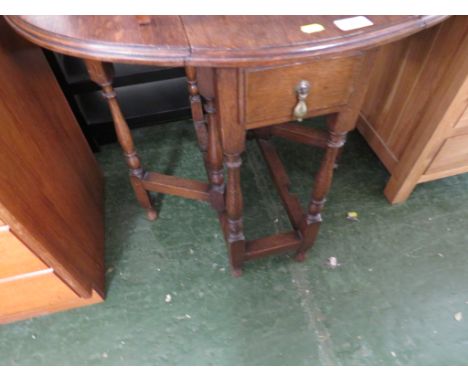 A SMALL OAK OVAL GATE-LEG DROP-LEAF TABLE WITH SINGLE DRAWER.