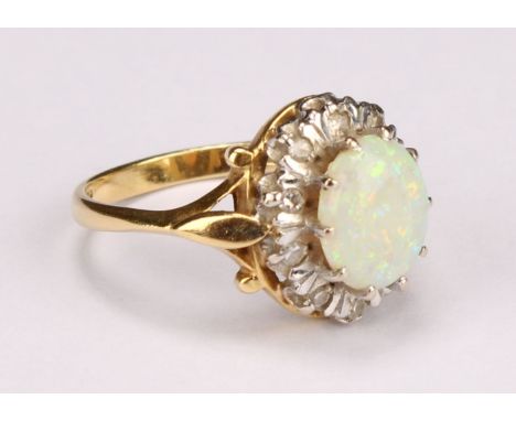 An 18ct gold opal and diamond cluster ring, the central polished oval opal cabochon surrounded by ten illusion set brilliants