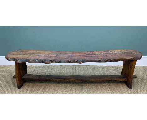 PROVINCIAL ELM PLANK LONG BENCH, the roughly hewn seat with natural edge raised on trestle supports joined by mortise and ten
