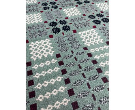 A GOOD WELSH WOOLLEN TAPESTRY BLANKET green ground with repeat geometric patterns in black, red, flecked grey and cream, 207 
