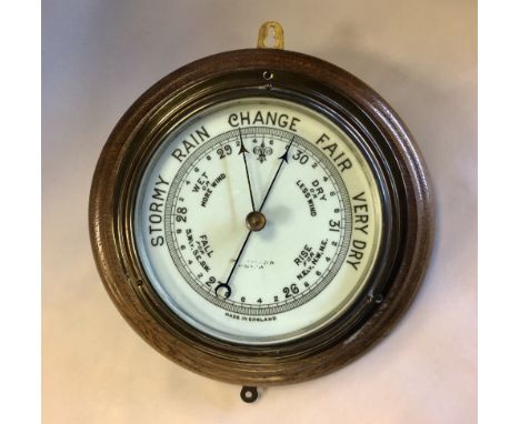Victorian lacquered brass cased aneroid barometer, on oak mount, 27cm diameter (wear to dial)