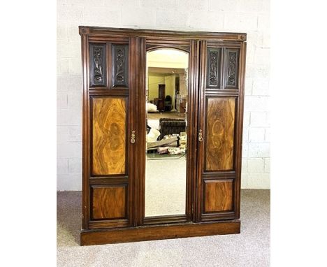 An Edwardian walnut and beech triple wardrobe, with mirrored door and two panelled doors, 200cm high, 157cm wide