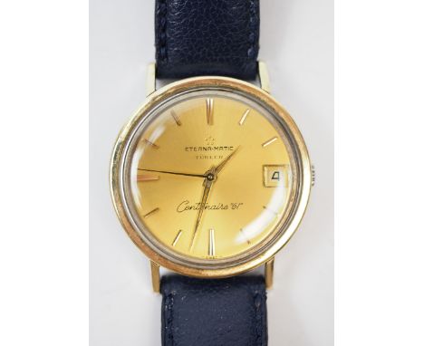 Eterna-Magci: Centenaire 61 Automatic Uhr.Goldenes Zifferblatt, mit Datum, Lünette in Vollgold, am blauen Lederarmband.Zustan