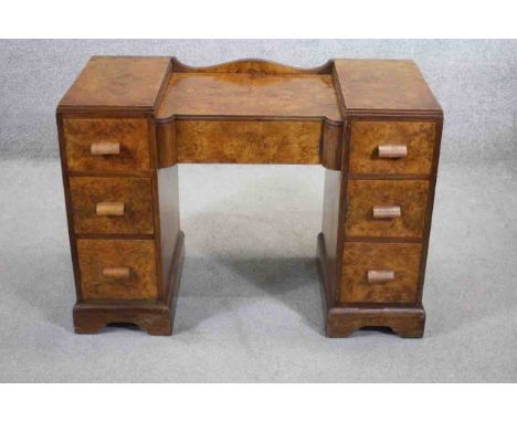 A mid century burr walnut Art Deco style dressing table or writing desk with central frieze drawer on shaped bracket feet. H.