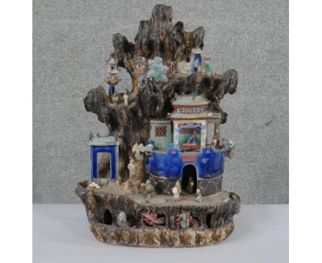 A Chinese tileworks style glazed ceramic mountain temple group with figures. H.46 W.37 D.16cm 