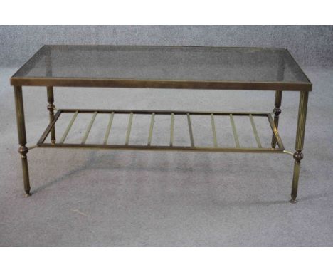 A mid century vintage smoked glass and brass coffee table with slatted magazine rack undertier. H.40 W.90 D.46 cm. 