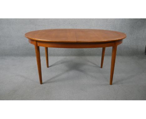 A mid century vintage teak dining table fitted with integral fold out central extension leaf. H.152 W.90cm (W.200cm extended)
