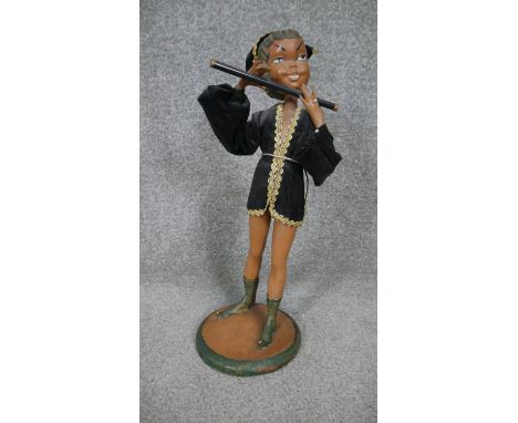 A vintage painted plaster figure of a pixie playing a pipe mounted on a circular base. H.47 D.16 