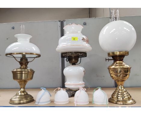 Two reproduction brass oil lamps; a similar glass table lamp; 4 Lladro bells 