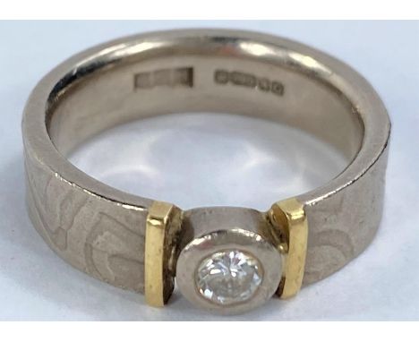 An 18 carat hallmarked gold wedding ring with inset diamond between yellow metal shoulders, 8 gm size K/L 