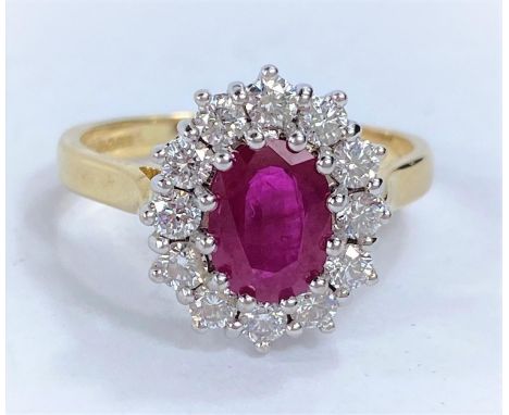 An 18ct hallmarked gold cluster dress ring with central ruby surrounded by 12 diamonds, 5.6gms size P, diamonds 2.3 - 2.5mm, 