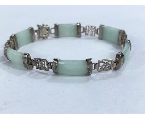 A vintage bracelet formed from oblong jade coloured stones joined by white metal links of Chinese characters, 13.9gms 