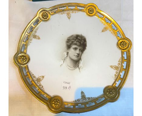 A ceramic plate with pierced gilt border, central hand painted portrait of a woman with impressed mark to back, 24cm dia&nbsp