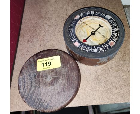 A compass in circular wooden case, from a Chinese junk 