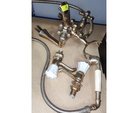 A pair of ceramic handled, brass taps and similar shower fittings. 