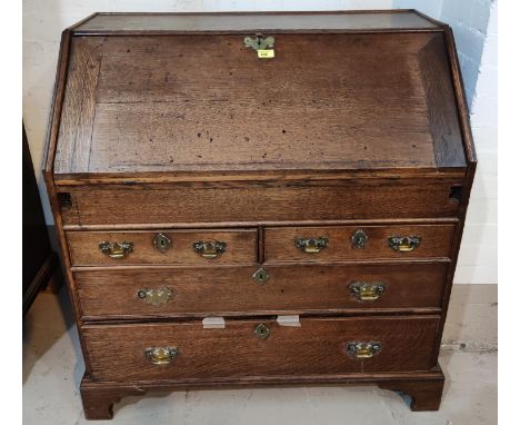 An 18th century Country made oak fall front bureau with fitted and stepped interior with secret compartment and well, 2 long 