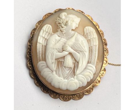 A large oval shell cameo, half length portrait of an angel with dove, the scalloped yellow metal surround stamped 9ct; a Vict