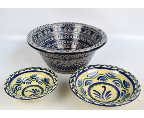 A large Spanish tin glazed circular bowl with linear motif decoration, diameter 43.5cm and two decorative blue and green deco