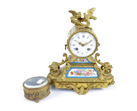 A late 19th century French gilt metal eight day mantel clock surmounted with two cast birds, wreath and torchère above circul