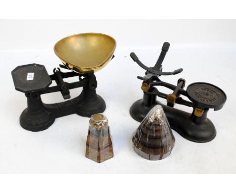 Two cast iron sets of scales, one marked 'Boots Nottingham', both with brass pouring bowls with a set of nine stacking circul