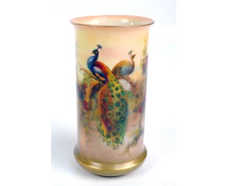 A Royal Worcester blush ivory cylindrical vase with flared rim, painted with couple of peacocks amongst pine branches, signed