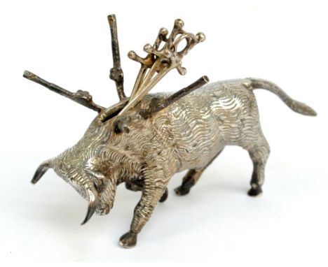 A Mexican sterling silver cocktail stick holder modelled as a bull, length 9cm, with three white metal sword shaped cocktail 