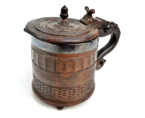 A rare 17th century lignum vitae York tankard, the hinged lid with acorn finial, stylised rose decoration and scrolling thumb