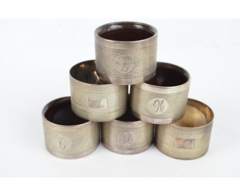 JOSEPH GLOSTER LTD; a set of four Edward VIII hallmarked silver engine turned decorated napkin rings with bakelite interiors,