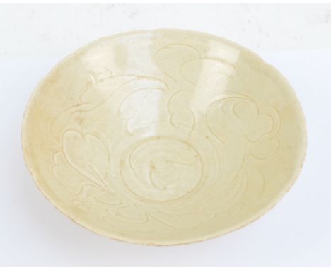 A Chinese Song Dynasty ceramic shaped circular bowl with incised decoration to the interior, with painted character marks to 