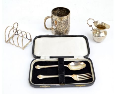 A group of variously hallmarked silver items comprising a small four section toast rack with central loop handle, Atkin Bros,