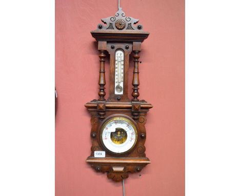 An Edwardian mahogany framed aneroid barometer with thermometer within a carved case.