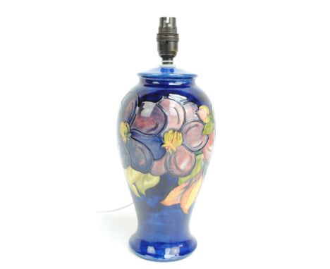 MOORCROFT; a baluster shaped lamp base in the 'Clematis' pattern on a blue ground with stamped mark to base and Royal Appoint