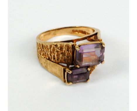 A 9ct yellow gold and emerald cut amethyst double offset stone ring with part textured band, size O, approx 5.6g.