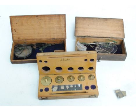 Two 19th century boxed sets of apothecary scales, one with brass pans, one with glass pans, both with weights and a cased set