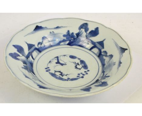 A late 19th century Japanese shallow circular bowl, painted in underglaze blue with architectural landscape to the flared rim