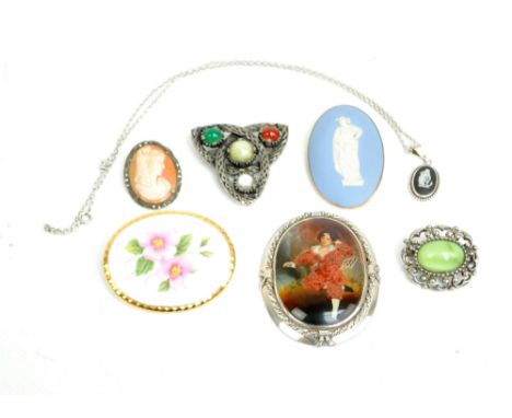 Six costume brooches including a silver mounted oval ecample, a sterling silver example depicting a boy after Thomas Lawrence