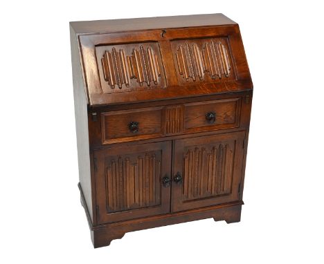 An oak linen fold decorated bureau raised on bracket feet, width 76cm.