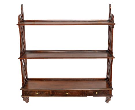 An early 20th century mahogany three shelf wall unit with three geometrically carved drawers, width 77cm.