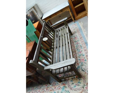 A teak slatted garden bench with wooden arms, width 161cm.