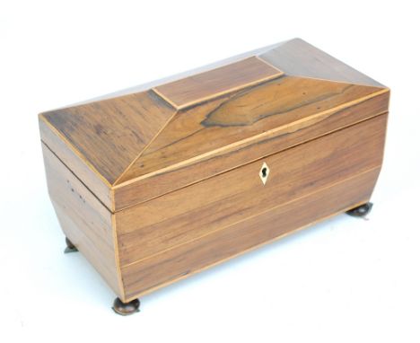 A 19th century rosewood sarcophagus shaped tea caddy on bun feet, the hinged lid enclosing two hinged internal sections and a