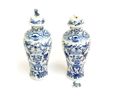 A pair of late 19th century Chinese baluster vases painted in underglaze blue with large jars and covers on stands flanked by