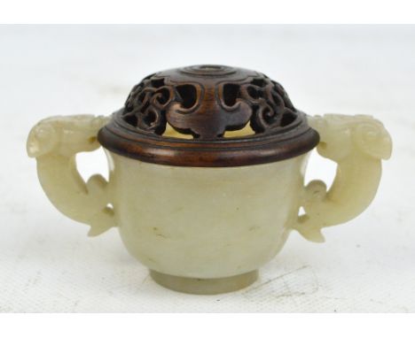 An 18th/19th century Chinese carved pale celadon green jade cup with twin handles modelled as mythical beasts, diameter 6cm, 