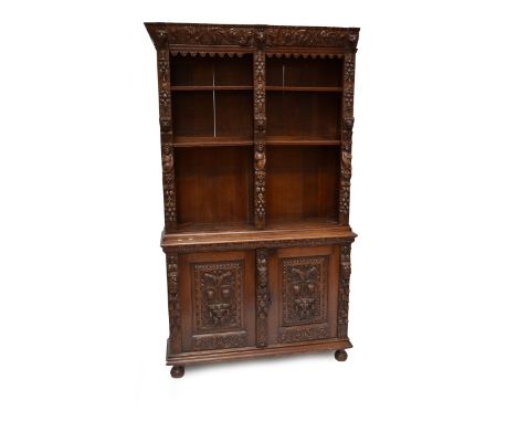 A late Victorian elaborately carved oak bookcase on cupboard, the upper section set with adjustable shelves and caryatid figu