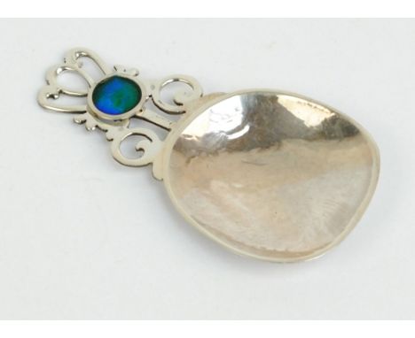 JOHN STUART SHELLIS; an Elizabeth II hallmarked silver Liberty style caddy spoon with hammered body and pierced scroll handle