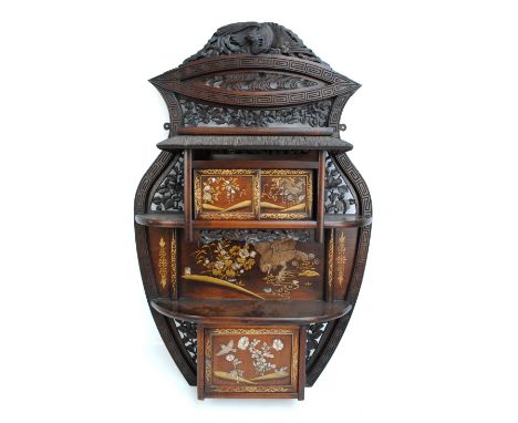 A Japanese Meiji period Shibayama style wall hanging cabinet with phoenix carved and pierced foliate pediment above a compart