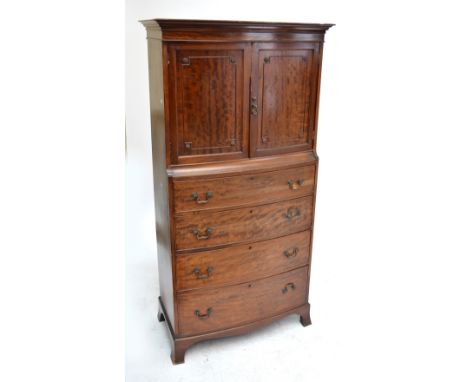 A reproduction mahogany slightly bowfronted tallboy with cornice above two hinged doors enclosing a shelf, four graduated dra