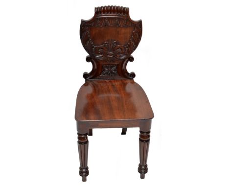 A Regency mahogany shield back hall chair with shaped seat and fluted tapering front legs to peg feet.   CONDITION REPORT:  H