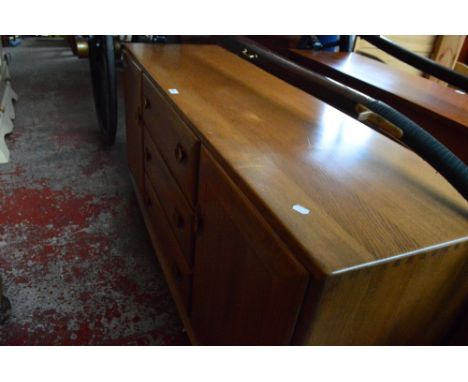 A golden oak Ercol sideboard with three central drawers flanked by doors, width 157cm..