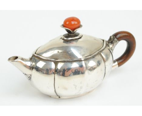 A late 19th/early 20th century Chinese white metal saffron pot of shaped oval form, with gadrooned sides, with wooden handle 